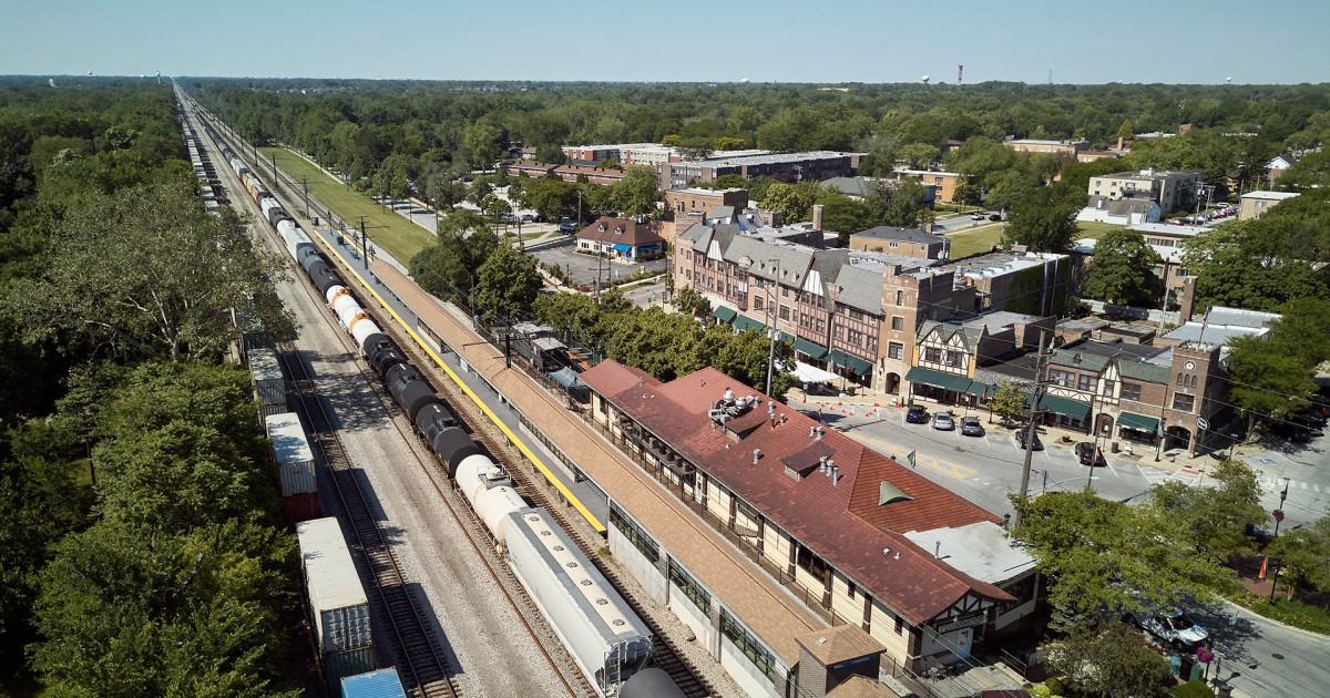 Aerial photo of train station, train tracks, small downtown buildings