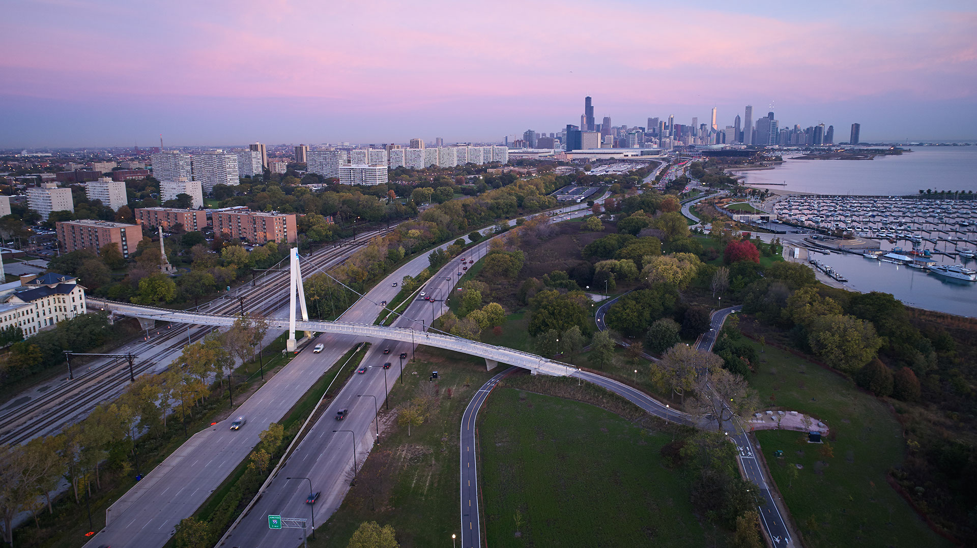 Pedestrian bridge over highway and railroad. Chicago skyline