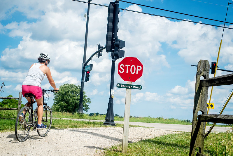 A person on a bike stops at a stop sign.