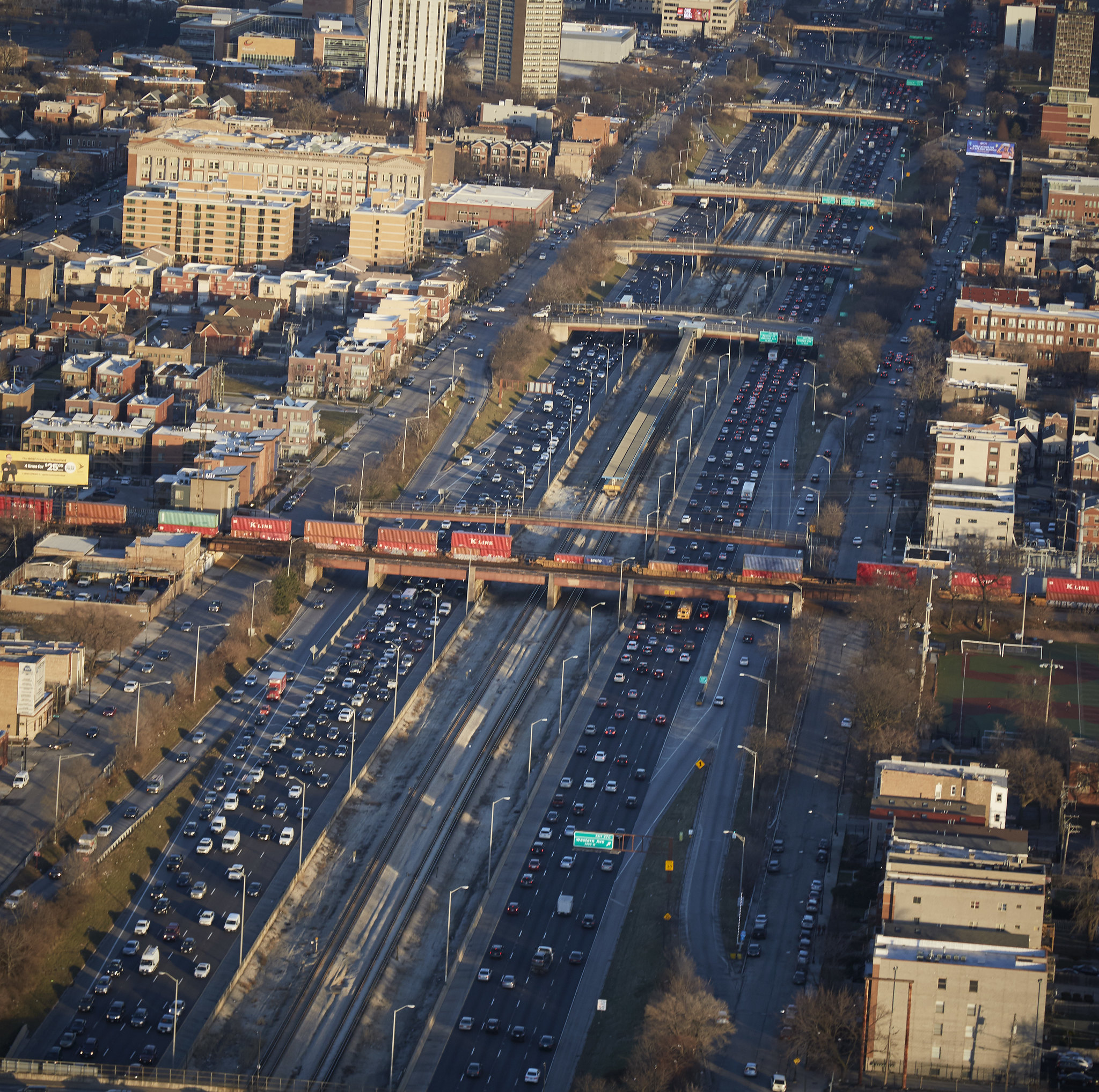 Train crosses on bridge over expressway filled with cars