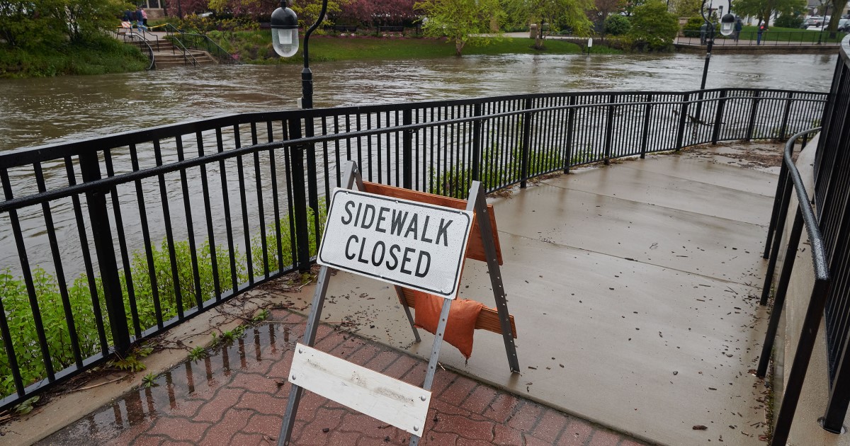 Sidewalk closed sign on walkway next to river