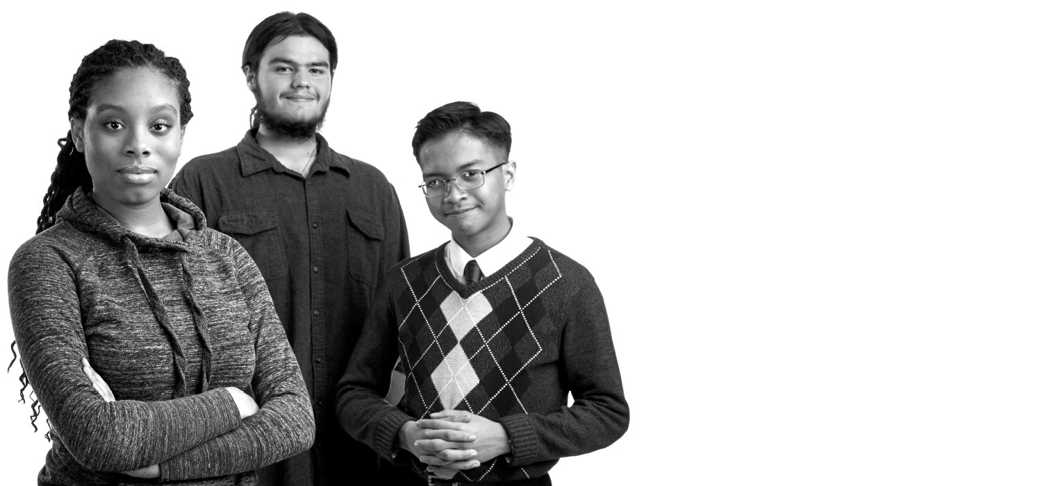 The three students stand together and smile at the camera.