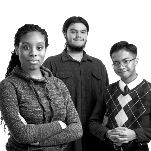 The three students stand together and smile at the camera.